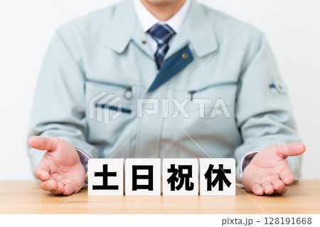 土日祝休みのブロックと作業着を着たミドル男性ビジネスマン 128191668