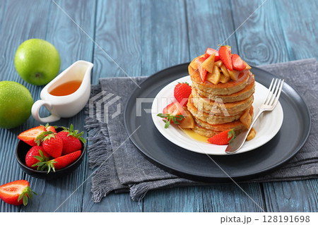 pancakes topped with apple slices and strawberries pancakes topped with apple slices and strawberries 128191698