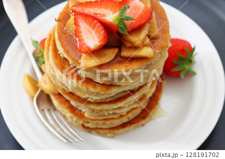 pancakes topped with apple slices and strawberries pancakes topped with apple slices and strawberries 128191702
