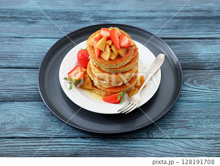 pancakes topped with apple slices and strawberries pancakes topped with apple slices and strawberries 128191708