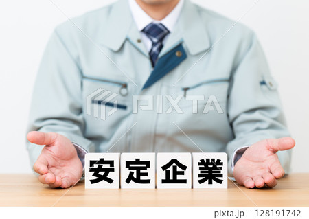 安定企業のブロックと作業着を着たミドル男性ビジネスマン 128191742
