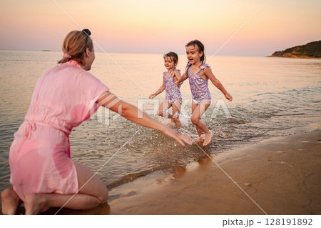 Joyful moments at the beach with family under a sunset sky Joyful moments at the beach with family under a sunset sky 128191892