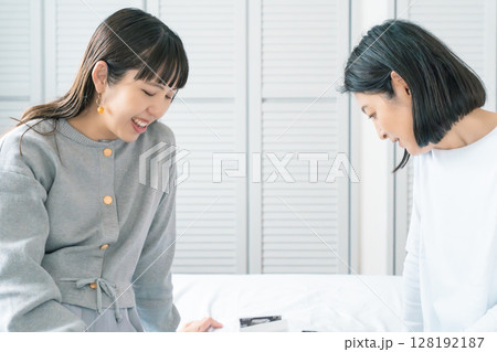 エコー写真を見ながら、赤ちゃんが生まれてくるのが待ち遠しい母と娘 128192187
