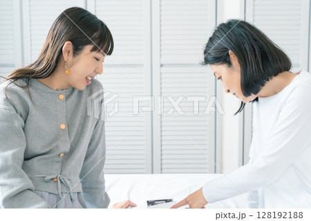 エコー写真を見ながら、赤ちゃんが生まれてくるのが待ち遠しい母と娘 128192188