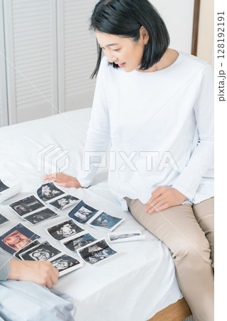 エコー写真を見ながら、赤ちゃんが生まれてくるのが待ち遠しい母と娘 エコー写真を見ながら、赤ちゃんが生まれてくるのが待ち遠しい母と娘 128192191