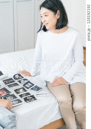 エコー写真を見ながら、赤ちゃんが生まれてくるのが待ち遠しい母と娘 128192192