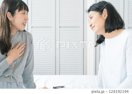 エコー写真を見ながら、赤ちゃんが生まれてくるのが待ち遠しい母と娘 128192194