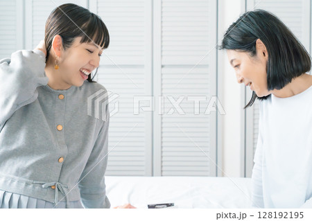 エコー写真を見ながら、赤ちゃんが生まれてくるのが待ち遠しい母と娘 128192195