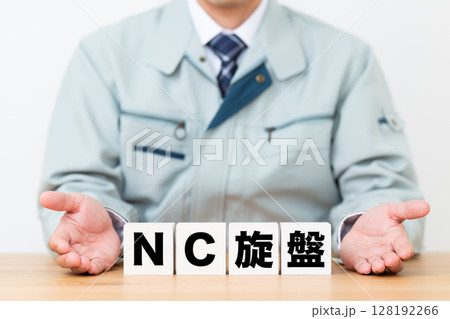 NC旋盤のブロックと作業着を着たミドル男性ビジネスマン 128192266