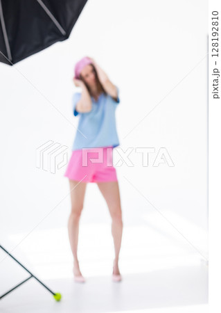Beautiful girl in pink beret and shorts and light blue t-shirt posing in studio on white background. Vertical photo. Blurred photo. High quality photo Beautiful girl in pink beret and shorts and light blue t-shirt posing in studio on white background. Vertical photo. Blurred photo. High quality photo 128192810