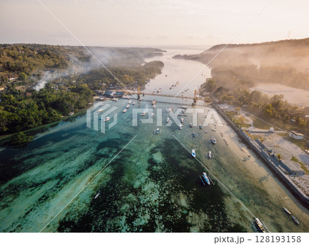 Aerial view of a bridge connecting two tropical islands over a narrow ocean channel. Nusa Lembongan and Nusa Ceningan bridge. Aerial view of a bridge connecting two tropical islands over a narrow ocean channel. Nusa Lembongan and Nusa Ceningan bridge. 128193158