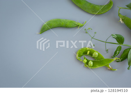 A branch of green peas with open pods close-up A branch of green peas with open pods close-up 128194510