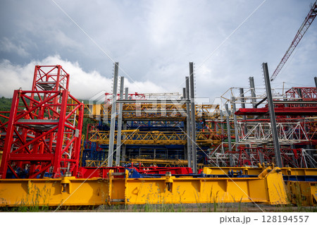 Colorful construction crane parts stored outdoors at industrial site 128194557