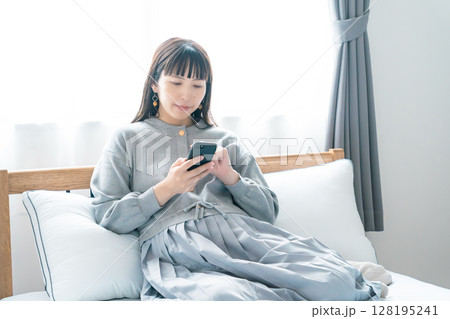 寝室で出産の準備に向けたリストを確認している妊婦 128195241