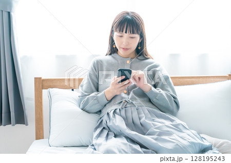 寝室で出産の準備に向けたリストを確認している妊婦 寝室で出産の準備に向けたリストを確認している妊婦 128195243