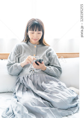 寝室で出産の準備に向けたリストを確認している妊婦 128195255