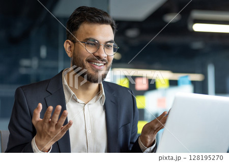 Mature professional businessman engaging in an online discussion on a laptop. Highlights confidence and modern corporate communication. Ideal for depicting business interactions 128195270