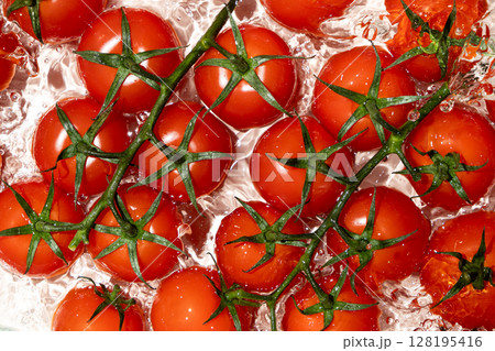 Vegetable background of fresh whole tomatoes in water, splash of water, top view. Vegetable background of fresh whole tomatoes in water, splash of water, top view. 128195416