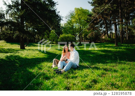 Joyful couple enjoying a sunny day in a peaceful green park setting Joyful couple enjoying a sunny day in a peaceful green park setting 128195878
