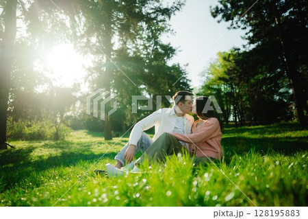 Couple enjoying a romantic moment in a sunlit park in spring Couple enjoying a romantic moment in a sunlit park in spring 128195883