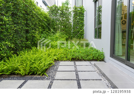 Modern design home garden landscaping. Flower garden and green plant with brick border and pedestrian pathway. Modern design home garden landscaping. Flower garden and green plant with brick border and pedestrian pathway. 128195938