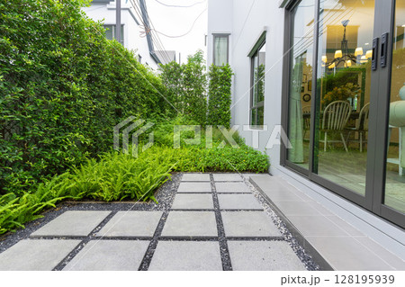 Modern design home garden landscaping. Flower garden and green plant with brick border and pedestrian pathway. Modern design home garden landscaping. Flower garden and green plant with brick border and pedestrian pathway. 128195939