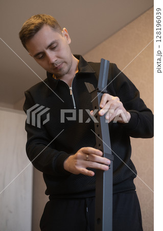 Furniture expert assembles furniture at home transforming empty space into a comfortable stylish living area. 128196039