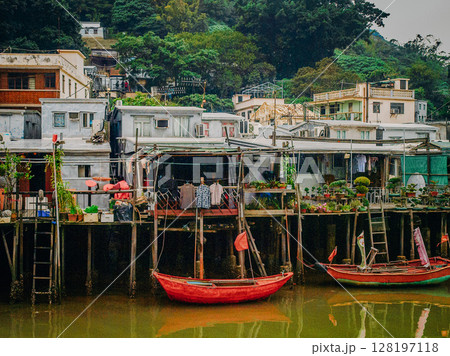Traditional Stilt Houses In Hong Kong Village: Colorful Weathered Structures Built On Wooden Pilings Amid Urban Surroundings And Mountain Backdrop In Southeast Asia Traditional Stilt Houses In Hong Kong Village: Colorful Weathered Structures Built On Wooden Pilings Amid Urban Surroundings And Mountain Backdrop In Southeast Asia 128197118