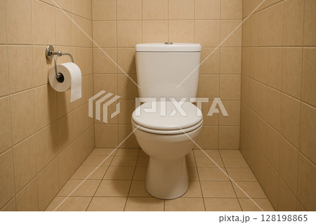 Modern white toilet in a clean tiled restroom with toilet paper holder and neutral beige ceramic wall and floor tiles, AI Generative 128198865