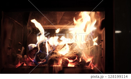 Burning fire logs inside stone fireplace. Close-up view. Burning fire logs inside stone fireplace. Close-up view. 128199114