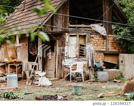 Improvised Housing With Makeshift Structures And Scattered Debris: A Scene Depicting Poverty, Unstable Living Conditions, And Everyday Struggles In An Urban Slum Environment. Improvised Housing With Makeshift Structures And Scattered Debris: A Scene Depicting Poverty, Unstable Living Conditions, And Everyday Struggles In An Urban Slum Environment. 128199327