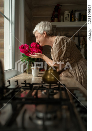 A Woman Joyfully Enjoying Beautiful Fresh Roses in a Cozy and Inviting Kitchen Setting A Woman Joyfully Enjoying Beautiful Fresh Roses in a Cozy and Inviting Kitchen Setting 128199998
