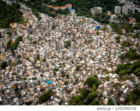 Aerial View Of Rocinha Favela In Rio De Janeiro: Dense Urban Landscape With Colorful Rooftops And Narrow Streets In The Largest Informal Settlement In Brazil Aerial View Of Rocinha Favela In Rio De Janeiro: Dense Urban Landscape With Colorful Rooftops And Narrow Streets In The Largest Informal Settlement In Brazil 128200316