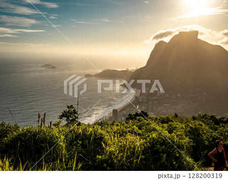 Golden Sunset Over Rio De Janeiro From Two Brothers Mountain: Dramatic Sunbeams Streaming Through Coastal Peaks Above The Atlantic Ocean And Leblon Beach 128200319