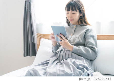 寝室でタブレットを見ながら出産準備をする妊婦 寝室でタブレットを見ながら出産準備をする妊婦 128200631