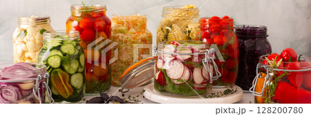 Fresh vegetables like cabbage, tomatoes, cucumbers and radishes, onions, corn, peppers and cauliflower, fermenting naturally to boost health and preserve nutrients, banner 128200780
