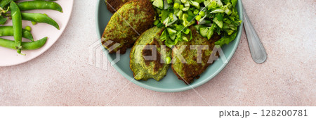 Enjoy zucchini and broccoli pancakes paired with a fresh mixed salad featuring cucumbers, young peas, and radishes Enjoy zucchini and broccoli pancakes paired with a fresh mixed salad featuring cucumbers, young peas, and radishes 128200781