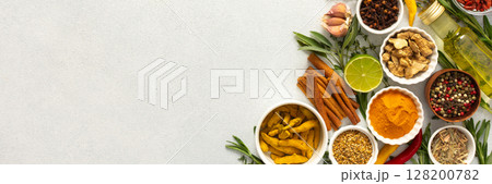 A wide selection of cooking spices and herbs on a gray background, perfect for adding depth to any dish, top view and copy space, banner A wide selection of cooking spices and herbs on a gray background, perfect for adding depth to any dish, top view and copy space, banner 128200782