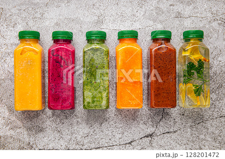 Colorful detox juices in plastic bottles on grey Colorful detox juices in plastic bottles on grey 128201472