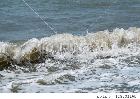 Sea water splashing over the stones on the beach Sea water splashing over the stones on the beach 128202169