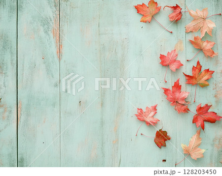 Distressed blue wooden background adorned with vibrant autumn maple leaves. 128203450