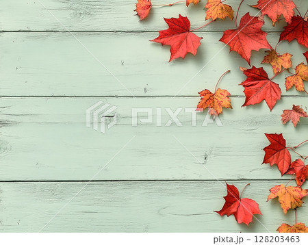 Distressed blue wooden background adorned with vibrant autumn maple leaves. 128203463