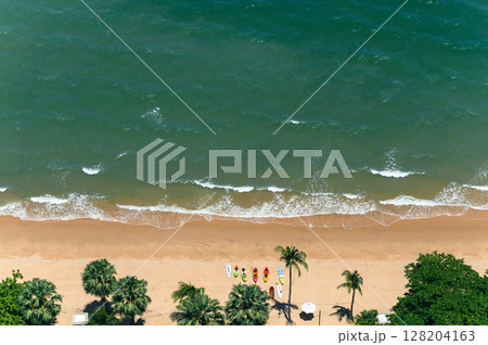 Above view of Pattaya beach in the summer season. High angle shot aerial of beautiful tropical sea with soft waves. Above view of Pattaya beach in the summer season. High angle shot aerial of beautiful tropical sea with soft waves. 128204163