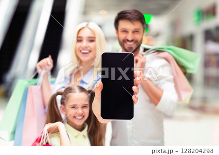 Shopping App. Happy Family Showing Blank Smartphone Screen Spending Time In Mall. Mockup, Shallow Depth 128204298