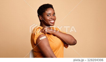 Successful Coronavirus Vaccination. Black Woman Showing Vaccinated Arm After Covid-19 Vaccine Injection Shot Posing Smiling To Camera On Beige Background. Corona Virus Immunization Concept. Panorama Successful Coronavirus Vaccination. Black Woman Showing Vaccinated Arm After Covid-19 Vaccine Injection Shot Posing Smiling To Camera On Beige Background. Corona Virus Immunization Concept. Panorama 128204306