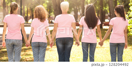 Female Unity. Diverse Women In Pink T-Shirts Holding Hands Standing Back To Camera Supporting Each Other In Park. Panorama 128204492