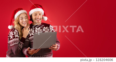 Lovely lady and her boyfriend in winter outfits shopping for Christmas gifts online on laptop, red background 128204606