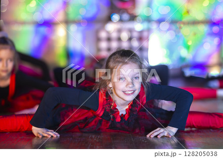 A funny little girl with a good stretch does a dance on stage. A funny little girl with a good stretch does a dance on stage. 128205038