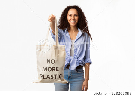 No More Plastic. Smiling Lady Showing Eco Shopper Bag With Inscription Standing On White Background In Studio. Conscious Consumption And Ecology Protection Concept No More Plastic. Smiling Lady Showing Eco Shopper Bag With Inscription Standing On White Background In Studio. Conscious Consumption And Ecology Protection Concept 128205093