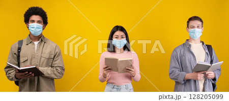 New normal, education and covid-19 pandemic. Young european, asian and african american students in protective masks read books and abstracts, isolated on orange background, copy space, studio shot 128205099
